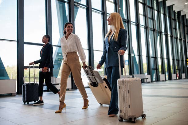 Travelers walking through an airport with their luggage